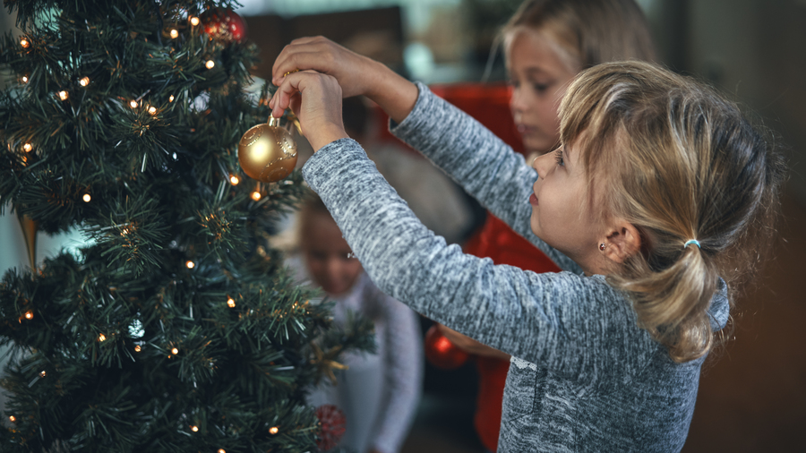 Two children decorating christmas tree