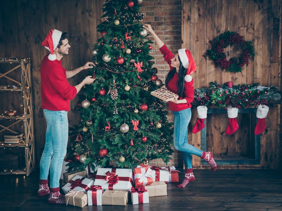 Couple of lover decorating christmas tree happily