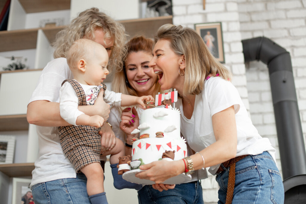 Three smilling womans celebrating birthday for cute little baby